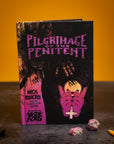 Book titled 'Pilgrimage of the Penitent' with a dark cover and pink text on a yellow background