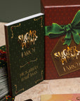 Sugar Plum Tarot book and packaging with a green ribbon on a textured surface