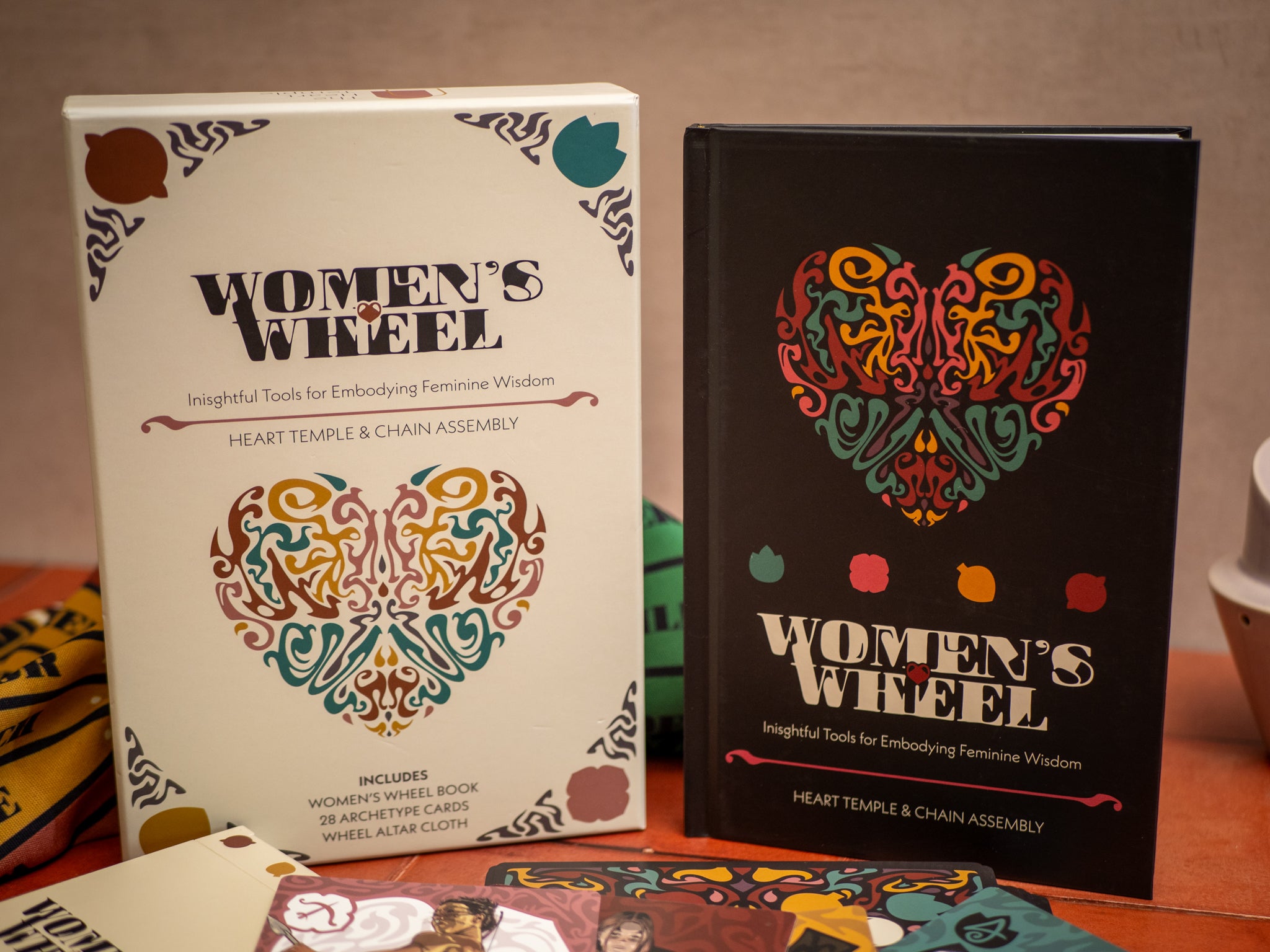 Two 'Women's Wheel' books with colorful designs on a wooden surface.