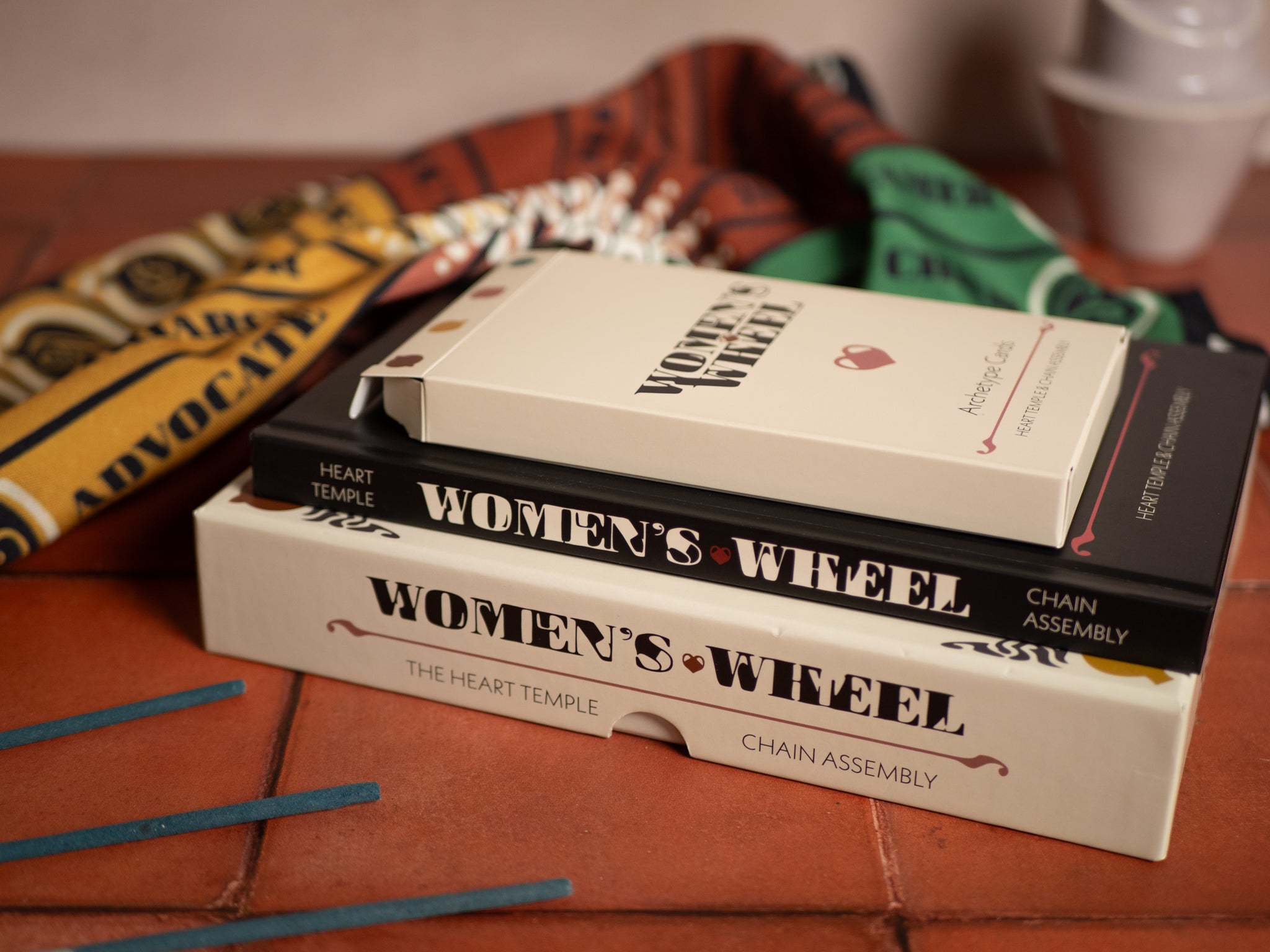 Stack of books titled 'Women's Wheel' on a textured surface with a blurred background